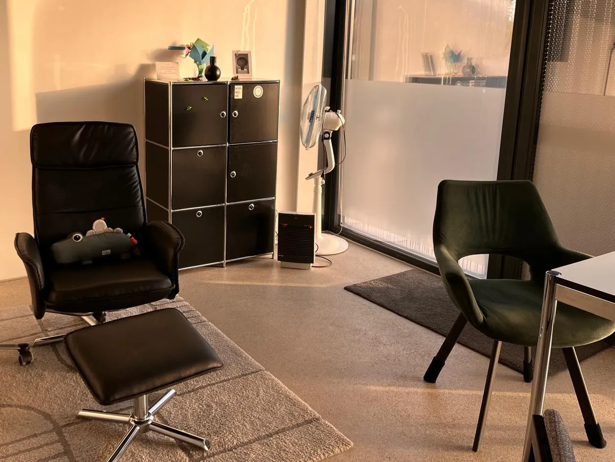 Salle de séance du centre : un fauteuil inclinable et son repose-pieds en cuir noir, dans une lumière dorée